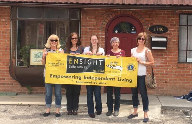 People hold Ensight sign saying empowering independent living