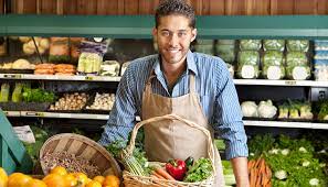 grocery clerk standing behind produce counter